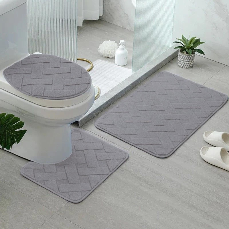 jogo de tapetes para banheiro 3 peças na cor cinza dentro do banheiro ao lado de pia e box