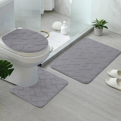 jogo de tapetes para banheiro 3 peças na cor cinza dentro do banheiro ao lado de pia e box