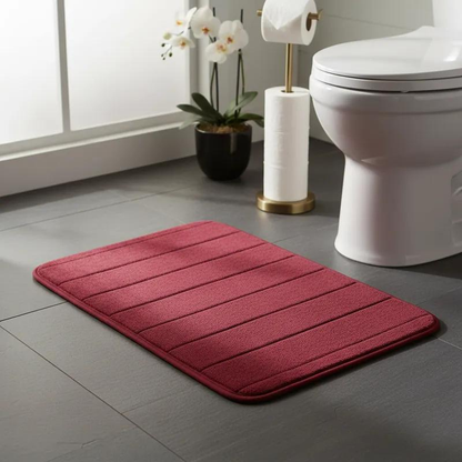 tapete de banheiro soft super absorvente cor vermelho ao lado do vaso sanitário e papel higiênico
